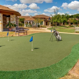 A beautiful community at the heart of all your passions putting green with benches